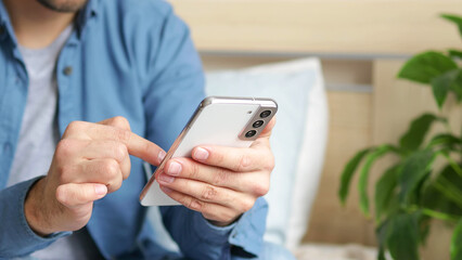 A man using a smartphone presses with his finger, reads social networks on the Internet, typing text or shopping online