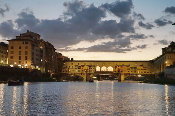 Ponte Vecchio at sunset seen from a boat on the Arno River in Florence, Tuscany, Italy