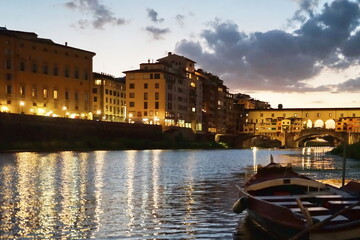 Ponte Vecchio at sunset seen from a boat on the Arno River in Florence, Tuscany, Italy