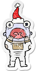 distressed sticker cartoon of a alien gasping in surprise wearing santa hat