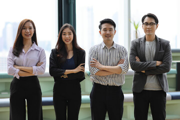 Collaborative process of young asian business people team working together discussing, researching, brainstorming and planning while crossed arms in business office building and city background