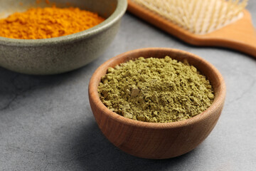 Henna and turmeric powder on light grey table, closeup