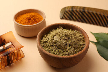 Comb, barrette, henna and turmeric powder on beige background, closeup. Natural hair coloring