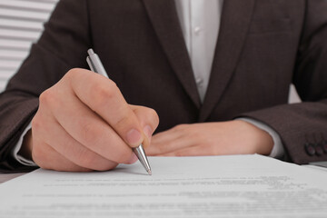 Naklejka premium Man signing document at table, closeup view