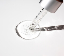 Cosmetic oil and glass pipette on a gray background in close-up. Side view, text space.