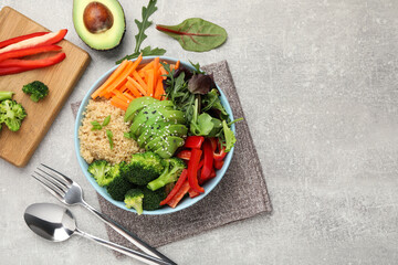 Delicious vegan bowl with bell peppers, avocados and broccoli on grey table, flat lay. Space for text