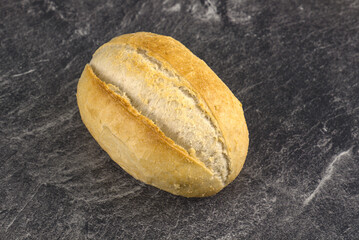 Ein knuspriges, frisches Brötchen (Semmel) auf einem marmorierten Hintergrund