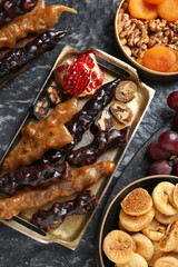 Delicious sweet churchkhelas and ingredients on textured table, flat lay