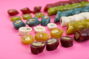 Many different delicious churchkhelas on pink background, closeup