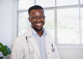 Portrait of smiling Black doctor in front of window in clinic