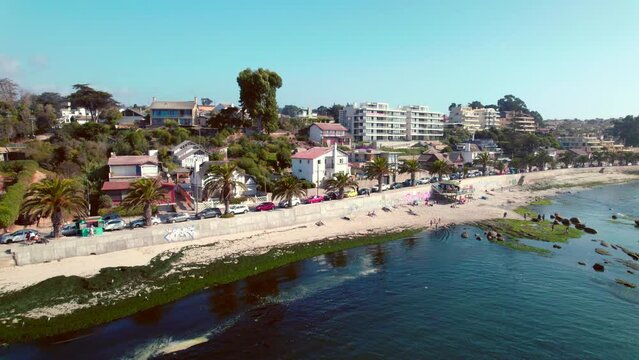 Slow motion aerial shot toward luxury seafront apartments looking onto Pejerrey beach