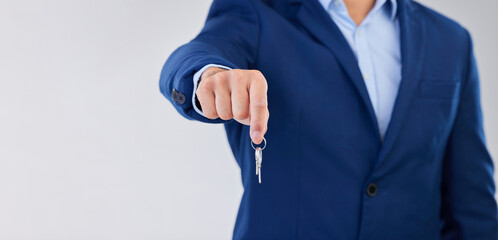 Fototapeta premium Key, real estate and mockup with a property agent in studio on a white background for the sale of a home. Mortgage, investment and opportunity with the hand of a realtor holding keys to an apartment