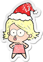 distressed sticker cartoon of a girl pouting wearing santa hat