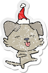 distressed sticker cartoon of a dog dancing wearing santa hat