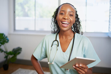 Portrait of a young Black female doctor, laughing with digital tablet