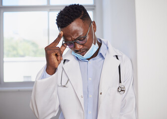 Black doctor looks upset after surgery wearing medical mask, stressed