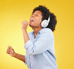 Black woman, singing with headphones and freedom, music and happiness with invisible mic on yellow...