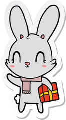 sticker of a cute cartoon rabbit with christmas present