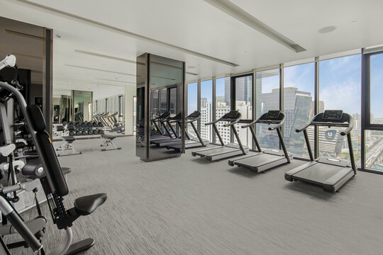 Modern gym interior with sport and fitness equipment overlooking building view , fitness center interior, interior of crossfit