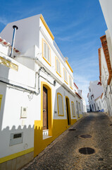 Obraz premium Narrow street of Salema. Whitewashed houses of the small authentic fishing village. Faro, Algarve, Southern Portugal.