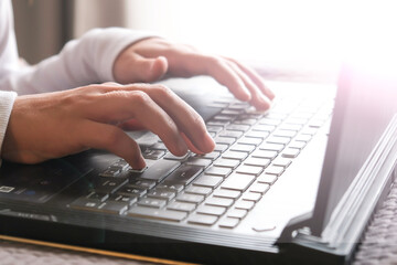 Hands on the laptop keyboard typing.