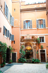Beautiful patio with a fountain,statues and greenery in a building in central Rome, Italy.