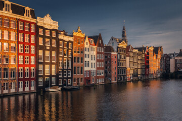 Naklejka premium Canals in Amsterdam - the capital of the Netherlands in a night scenery. The huge amount of colors adds a beautiful look to this architecture.