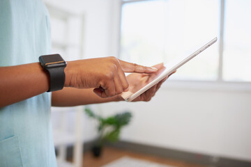 Close up of nurse or doctor entering patient information into digital tablet