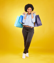 Black woman with shopping bag, smile with fashion and retail in portrait on yellow studio background. Happiness, female with discount and sale at boutique with designer brand, happy and mockup space