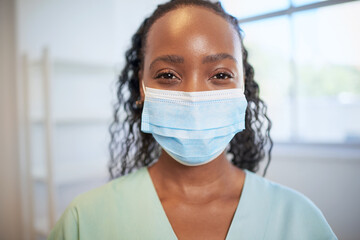 Close up portrait of junior doctor or nurse wearing surgical mask in scrubs