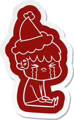 cartoon  sticker of a boy crying wearing santa hat