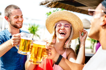 Trendy happy friends toasting beer at chiringuito beach bar - Summer vacation life style concept...
