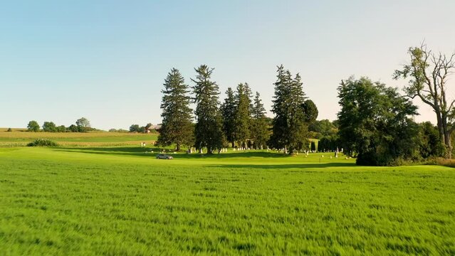 flying through a field revealing Gorham Cemetery. An old grave yard that with graves that date back to the the early America 1800s located in the country of New York State, USA