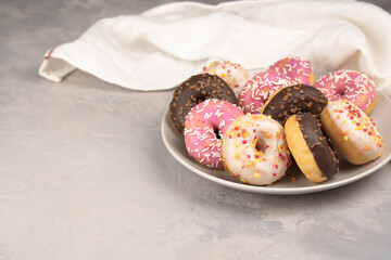 two donuts in a heartshape on a gray background on a white plate. Concept for Valentine's Day. Valentine's Day dessert. flatly space for text, copy space