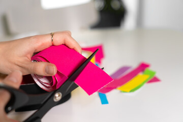 Close-up of women's hands cutting off part of the pink tape with scissors. Concept of self-care, healthy skin, self-care courses.