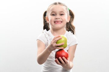 On a white background, the girl holds two green and red apples in her hands