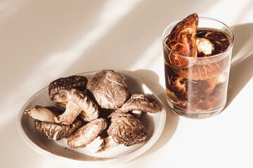 お皿に乗った干し椎茸と干し椎茸を一晩水に浸した干し椎茸の出汁が入ったグラス。