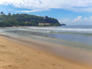 Beautiful sand beach and turquoise water. Summer holiday beach background. Ocean waves on empty tropical sand beach. Vertical background