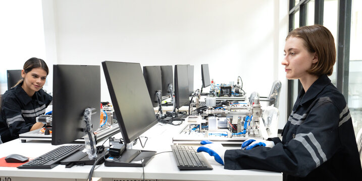 Engineer woman working on AI technology in robotics and electronics engineering laboratory. University students' research project is programming robot machine with intelligent mechanical control