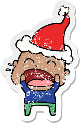 distressed sticker cartoon of a shouting bald man wearing santa hat
