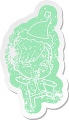 cartoon distressed sticker of a surprised girl in science fiction clothes wearing santa hat