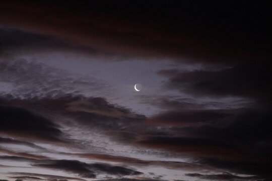 Crescent moon and clouds in night sky
