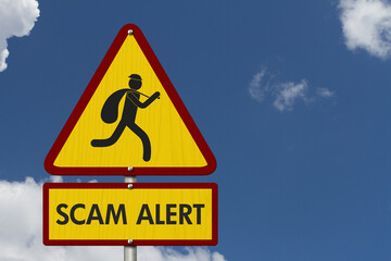 Scam Alert message on warning road sign on sky