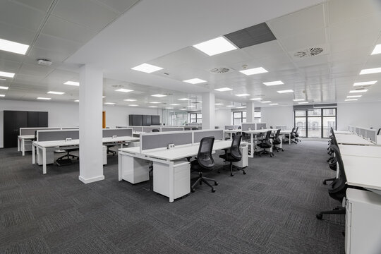 Empty gray office with tables and chairs before the start of the working day in the office center. Workplace concept with expensive furniture for skilled workers