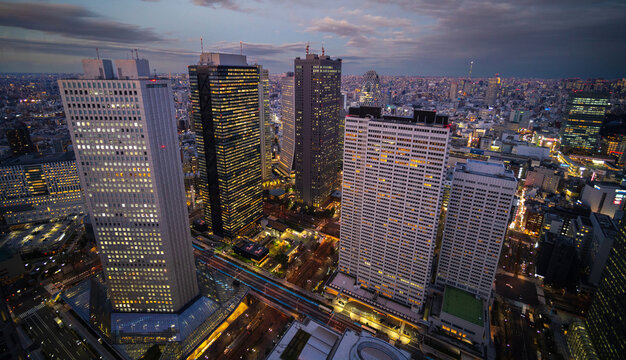 Tokyo Japan skyline under a cloudy sky taken soon after sunset with buildings lit up