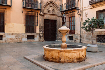 Fototapeta na wymiar Ancient marble fountain with a statue in the ancient city center of Valencia Spain