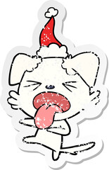 distressed sticker cartoon of a disgusted dog wearing santa hat