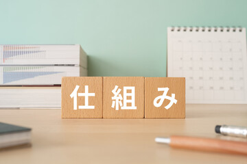 仕組みと書かれたブロックが置かれたデスク
