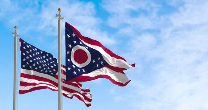Seamless loop in slow motion of the Ohio and US flags waving on a clear day