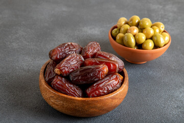 Dates fruit and green olives on a bright background.Traditional iftar table
